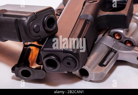 Vier Handfeuerwaffen, zwei schwarze Pistolen A 9mm und ein Kaliber 40 mit schwarzem Revolver, 38 Special und einem silbernen, 357 magnum auf weißem Grund Stockfoto