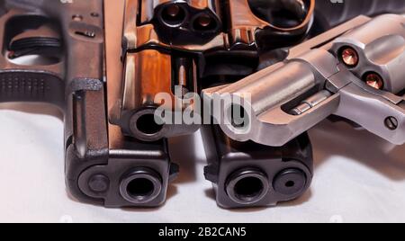 Vier Handfeuerwaffen, zwei schwarze Pistolen A 9mm und ein Kaliber 40 mit schwarzem Revolver, 38 Special und einem silbernen, 357 magnum auf weißem Grund Stockfoto