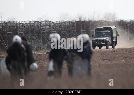 Orestiada, Griechenland. März 2020. Griechische Bereitschaftspolizisten patrouillieren nahe dem Zaun am geschlossenen Grenzübergang Kastanies im Nordosten Griechenlands, wo sich Flüchtlinge und Migranten auf der Grenzlinie zwischen Griechenland und der Türkei von türkischer Seite in der Nähe des Flusses Evros versammelten, um am 2. März 2020 nach Griechenland zu übertreten. Griechenland hat am Sonntag beschlossen, das Maß der Abschreckung an seinen Grenzen auf das Maximum zu erhöhen, da das Land vor kurzem mit einem bevorstehenden verstärkten Zustrom von Flüchtlingen und Migranten konfrontiert wird. Credit: Dimitris Tosidis/Xinhua/Alamy Live News Stockfoto