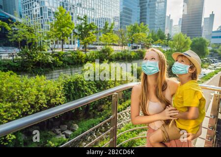 Mutter- und Sohn-Touristen in medizinischer Maske im Cheonggyecheon-Strom in Seoul, Korea. Der Cheonggyecheon-Strom ist das Ergebnis eines massiven Stadterneuerungsprojekts Stockfoto