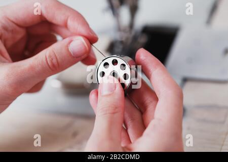 Ein Lederhandwerker stellt in seinem Laden Lederwaren an einer Nähmaschine her. Handgefertigte Arbeit. Nahaufnahme. Stockfoto