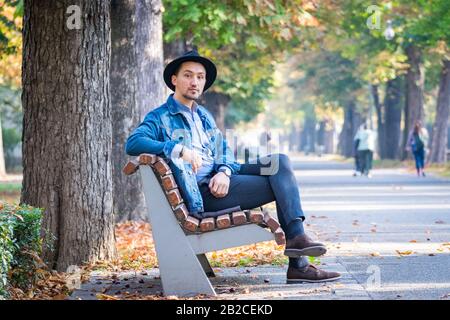 Porträt eines selbstbewussten und erfolgreichen jungen Mannes mit Denimjacke und blauem Hemd im Freien. Gutaussehender junger Mann draußen. Stockfoto