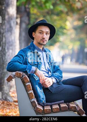 Porträt eines selbstbewussten und erfolgreichen jungen Mannes mit Denimjacke und blauem Hemd im Freien. Gutaussehender junger Mann draußen. Stockfoto