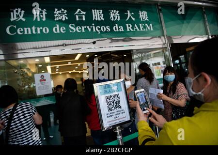 Macao, China. März 2020. Die Menschen scannen den QR-Code, um das Gesundheitsdokument auszufüllen, bevor sie in eine Regierungsdiensthalle in Macao, Südchina, am 2. März 2020 eindringen. Credit: Cheong Kam Ka/Xinhua/Alamy Live News Stockfoto