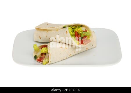 Zwei Speck-, Salat- und Tomatenwicklungen auf einem gegen Weiß isolierten Teller Stockfoto