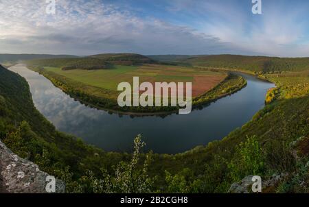 Dnestr (Dniester) Flussblick im Frühling. Der Fluss umgibt buntes Feld. Berghänge sind von üppiger grüner Vegetation bedeckt Stockfoto