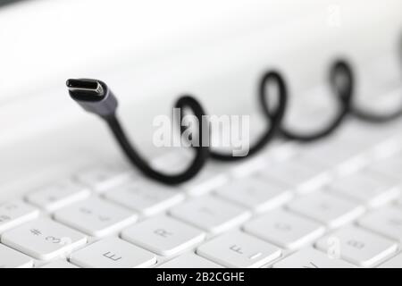 Das Kabel für die Verbindung mit dem Gerät liegt auf der Tastatur Stockfoto