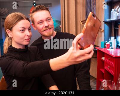 Kiew, Ukraine, 22. Februar 2020. Junge Frau und Mann nehmen selfie mit dem iPhone in eine Bar Stockfoto