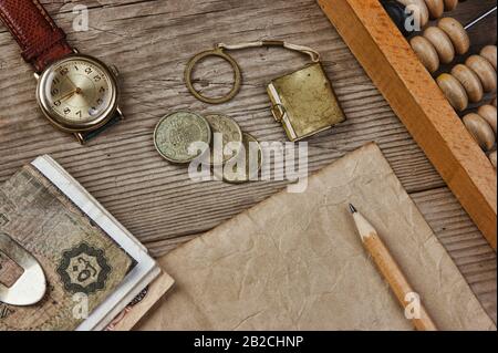 Alte Banknoten und Münzen und Abakus auf einem Holztisch Stockfoto