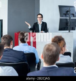 Selbstbewusster CEO, der jungen Mitarbeitern eine Präsentation vorgibt Stockfoto