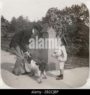 Antiquitätenfoto von 1898, kleiner Junge im Matrosenoutfit im Gespräch mit dem Mann mit Hund im Central Park, New York City, New York. QUELLE: ORIGINALFOTO Stockfoto