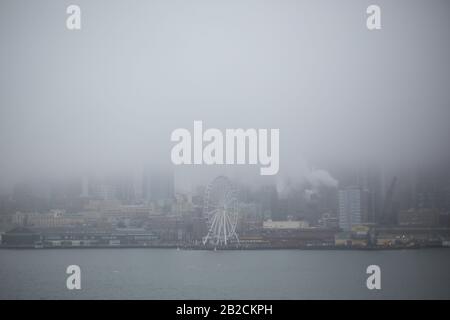 Blick auf das nebelige Seattle und das Seattle Great Wheel von einer Fähre auf den Puget Sound. Stockfoto