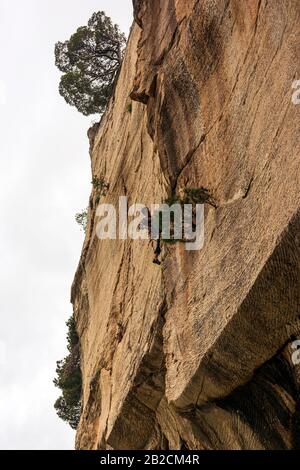 Penteli, Griechenland - 1. Mai 2019: Junger Mann klettert an einer Felswand in der Davelis-Höhle in Pentelis, einem Berg nördlich von Athen, Griechenland. Stockfoto