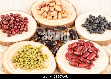 Die Sammlung verschiedener Bohnen auf den runden Holzbrettern. Stockfoto