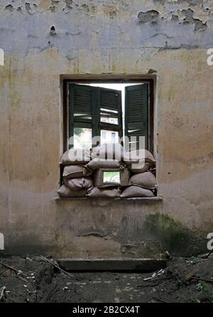 Sandsäcke stapelten sich an einem Fenster eines Hauses in der Pufferzone "Green Line" in Nikosia, Zypern Stockfoto