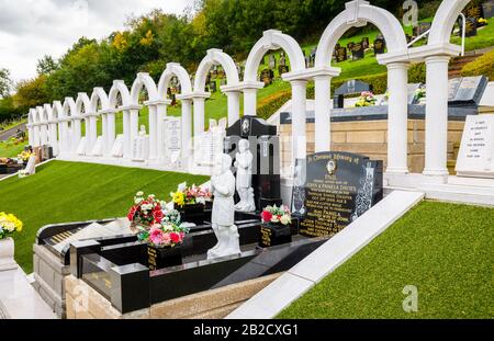 Gedenkbögen und Gräber, Bryntaf Cemetery, Aberfan Cemetery, Glamorgan, Wales, Ruhestätte von Opfern, die bei der Bergwerkskatastrophe von Aberfan 1966 ums Leben kamen Stockfoto