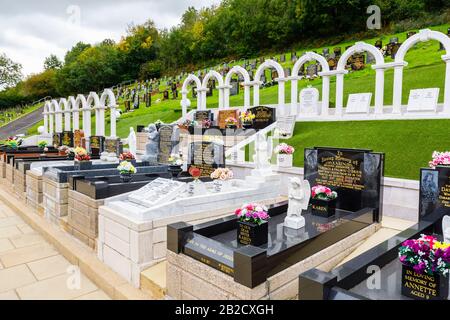 Gedenkbögen und Gräber, Bryntaf Cemetery, Aberfan Cemetery, Glamorgan, Wales, Ruhestätte von Opfern, die bei der Bergwerkskatastrophe von Aberfan 1966 ums Leben kamen Stockfoto