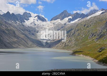 Oberaarhorn (r) und Oberaarrothorn (l) auf beiden Seiten der Oberaar Gletscher und die oberaar See und Damm in den Berner Alpen Schweiz Stockfoto