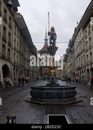 Der Zähringerbrunnen (Zähringen-Brunnen) ist ein Brunnen an der Kramgasse in der Altstadt von Bern, Schweiz. Die Zytglogge, die Wahrzeichen der mittelalterlichen Uhr Stockfoto