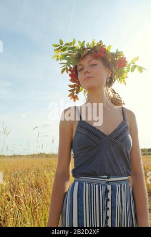 Syktyvkar, Russland - august 2019: Ein junges Mädchen slawischen Aussehens mit Dreadlocks in einem Kranz von Rowdblumen. Stockfotografie. Stockfoto