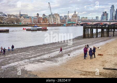 Das Vorwerk bei Ebbe an der Themse nahe Gabriels Wharf am Southbank mit Menschen und Hunden am Strand Stockfoto