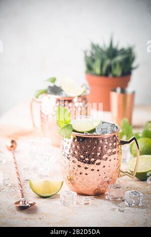 Cold Moscow Mules Cocktail mit Ingwerbier, Wodka, Limette. Weißer Steinhintergrund. Stockfoto