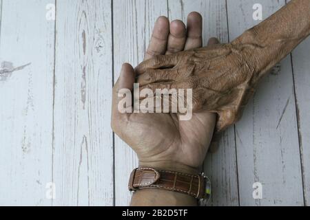 Draufsicht über die Hand des Mannes, die die Hand der älteren Frauen hält Stockfoto
