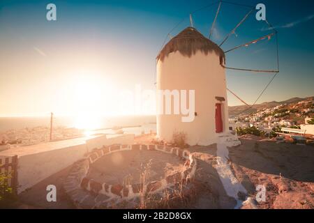 Wunderschöner Sonnenuntergang auf der Insel Mykonos, Griechenland. Alte Windmühle, berühmte Touristenattraktion mit Abendsonne. Ägeisches Meer im Hintergrund. Touristen Paradies an Stockfoto