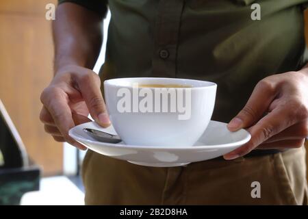 Nahaufnahme des Mannes, der Kaffee im Café serviert Stockfoto