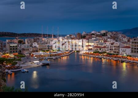 Wunderschöner Sonnenuntergang in der Stadt Agios Nikolaos, Hafen am ägetischen Meer. Krete, Griechenland. Ruhiger Hafen von Voulismeni Lake. Lange Promenade mit Restaurants. Pano Stockfoto