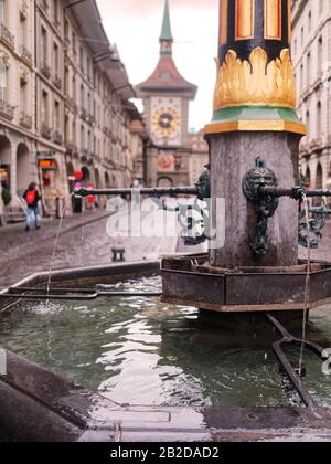 Der Zähringerbrunnen ist ein Brunnen an der Kramgasse in der Altstadt von Bern, Schweiz. Die Zytglogge, der Wahrzeichen des mittelalterlichen Uhrenturms im Backgrou Stockfoto