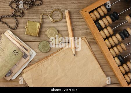 Alte Banknoten und Münzen und Abakus auf einem Holztisch Stockfoto