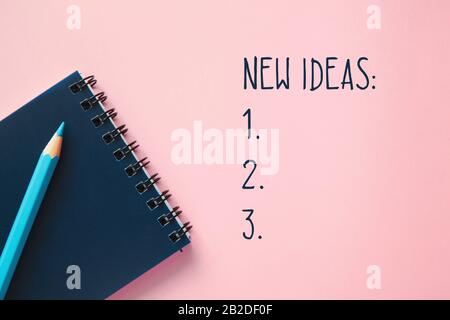 Dunkelblau Notebook, einen blauen pensil am trendigen rosa Hintergrund. Inspiration Konzept. Text neue Ideen und Checkliste, flach. Stockfoto