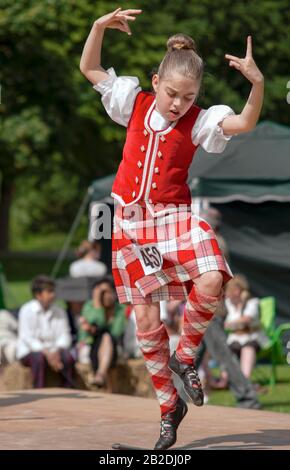 Junger schottischer Highland Dancer, der während eines Wettbewerbs in Colchester, Essex, England, einen Schwerttanz ausführte Stockfoto