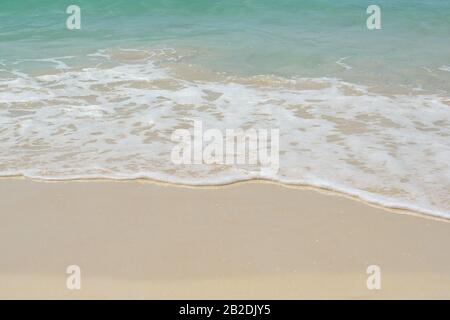 Schöne flauschige Wellen am Sandstrand. Blaues Kristallwasser. Fein, sauber, weiß, sandig wie Mehl. Sonnige tropische Küste von Ko Rok Yai, Thailand Stockfoto