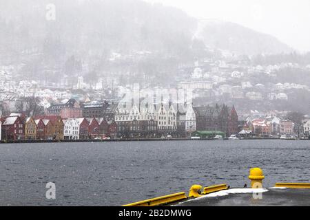 Winter in Bergen, Norwegen. Stark schneit. Blick vom alten Hafen der Stadt, Vaagen. Hanseatische Architektur der UNESCO in Bryggen. Mount Floeyen (Fløyen Stockfoto