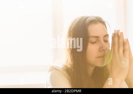 Frau übergibt sich, zu gott zu beten. Frau Bittet um Gottes Segen, um ein besseres Leben zu wünschen, um Vergebung zu bitten und an Güte zu glauben. Christliches Leben Stockfoto