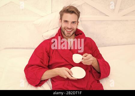 Gourmet Espresso. Ab Tag mit guten Kaffee. Entspannt zu Hause. Angenehme Momente. Kaffee am Morgen genießen. Gerne morgen. Schöner Mann trinken Kaffee am Morgen. Happy bärtiger Mann im Bett. Gute Laune. Stockfoto