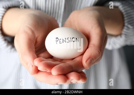 Frau hält Ei mit Aufschrift Pension, nah oben Stockfoto