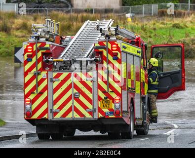 NANTGARW, IN DER NÄHE VON CARDIFF, WALES - FEBRUAR 2020: Feuerwehrmann, der in das Führerhaus eines Feuerzotters klettert, rief dazu auf, Menschen zu helfen, die von Überschwemmungen in Nantgarw eingeschlossen wurden Stockfoto