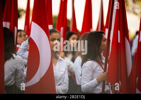 Izmir, Türkei - 29. Oktober 2016. Rote türkische Flaggen und junge Studentinnen halten sie bei der Zeremonie am Cumhuriyet Square Alsancak in Izmir. In Der Republik Stockfoto