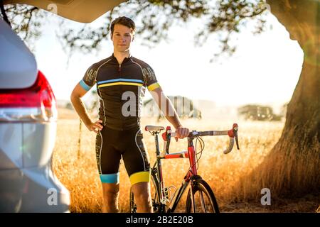 Porträt eines jungen Radfahrers, der mit seinem Fahrrad steht, bevor er eine Fahrt machte Stockfoto