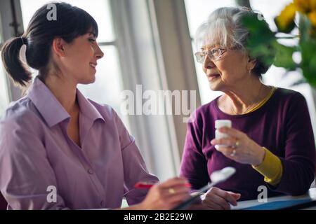 Seniorin spricht mit ihrem Arzt über verschreibungspflichtige Medikamente Stockfoto
