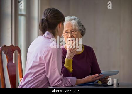 Ältere Frau im Gespräch mit ihrem Betreuer Stockfoto
