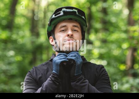 Junge Sportlerin trägt Helm über Waldhintergrund Stockfoto