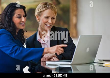 Zwei Kollegen arbeiten mit einem Laptop zusammen Stockfoto