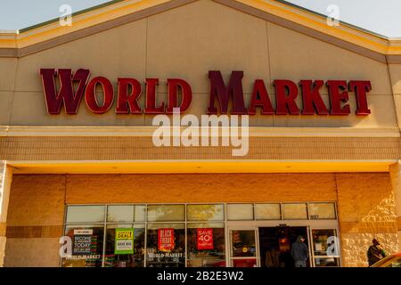 Charlotte, NC/USA - 9. November 2019: Mittlerer horizontaler Schuss von Schaufassen-Beschilderung für die Marke "World Market" in großen tiefroten Buchstaben. Stockfoto