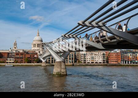 Fußgänger überqueren an einem sonnigen Sommertag die Millenniumsbrücke in Richtung Pauls Kathedrale. London, England, Großbritannien. Stockfoto