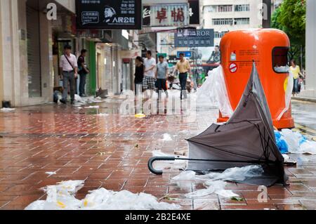 Zerbrochener Regenschirm und überströmter Mülleimer nach einem tropischen Sturm in Hongkong Stockfoto