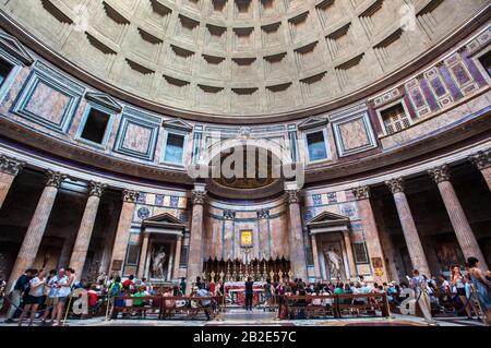 Touristen bewundern den Altar und die berühmte Kuppeldecke im Pantheon-Gebäude in Rom Stockfoto